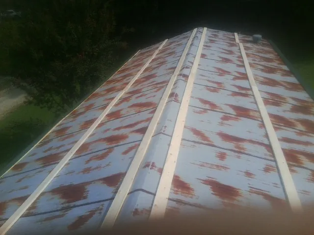Rusted metal roof panels with new wood purlins before replacement — Storm Damage Roof Repair in Collinwood by Roofing Brothers