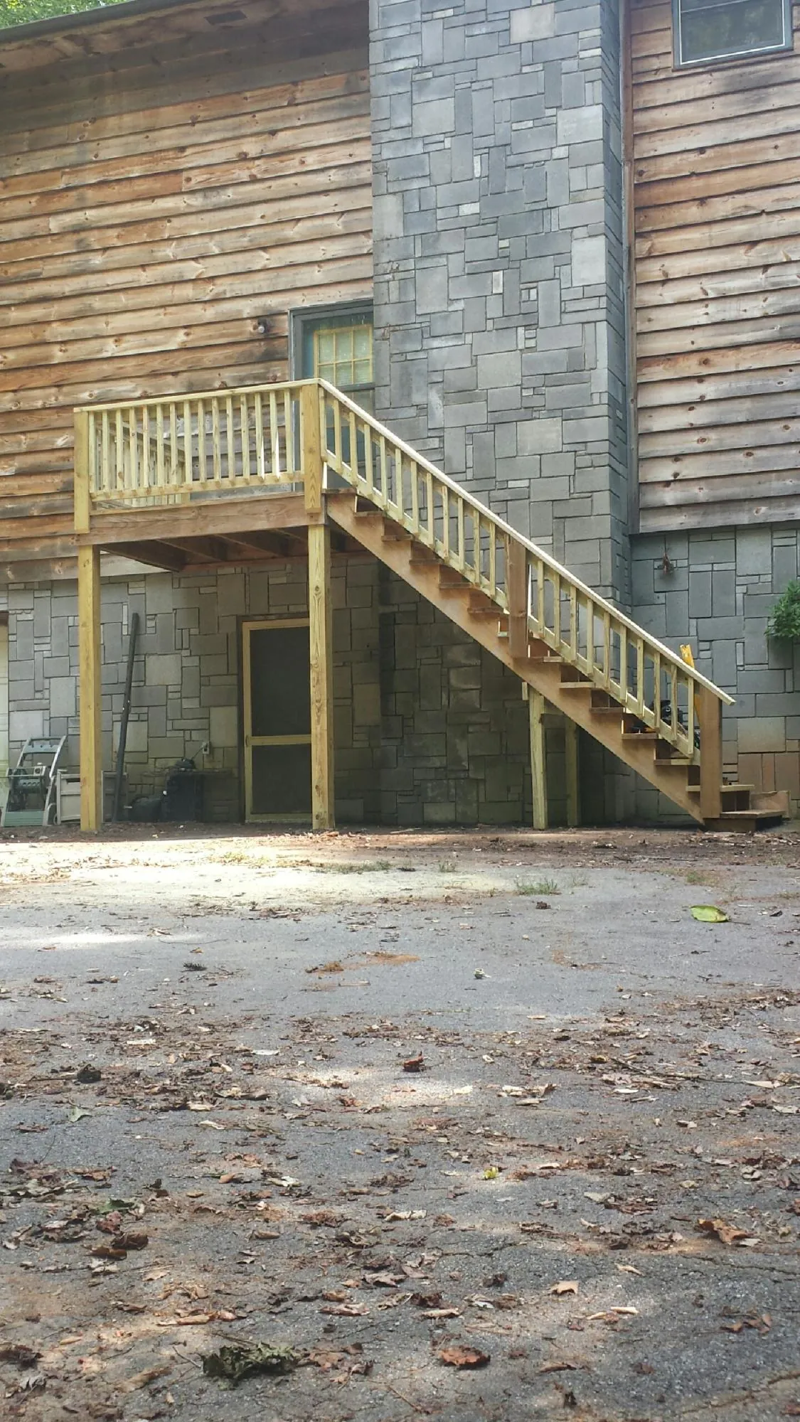 New pressure treated deck and stair landing on a log home in Collinwood