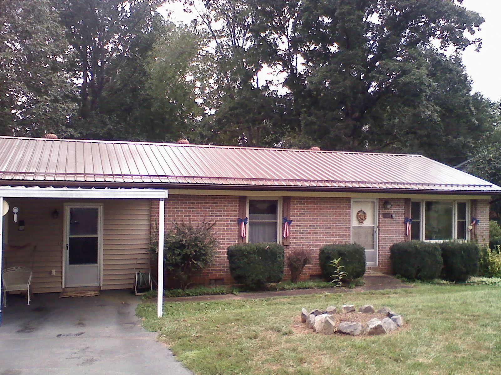 Bronze metal roof and carport on a brick ranch home — Roof Repair work by our crew in Collinwood